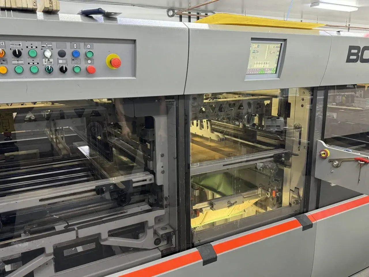 Bobst Die cutter from operator side, with the stripping and blanking unit featured, along with HUD operating machine