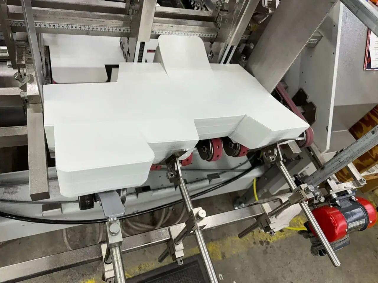 White folding carton in feeder