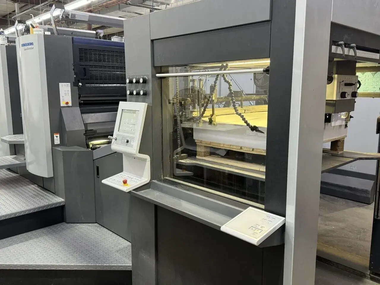 Offset Press from the rear of the press at the feeder, feeding sheets into the press