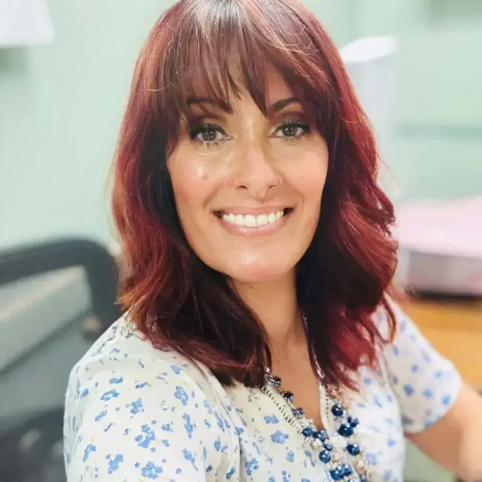 Mid-York CSR with Brown eyes, red hair, smiling in an office setting
