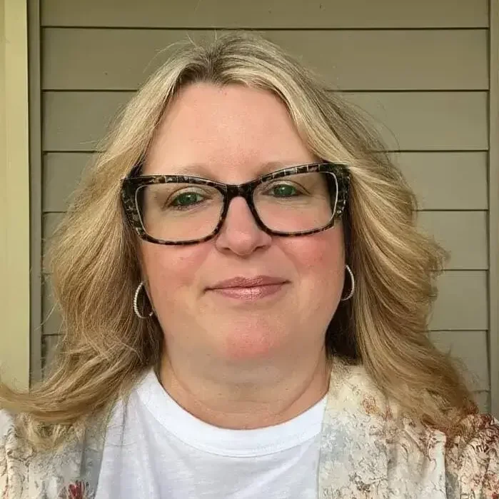 Mid-York CSR wearing eyeglasses with blonde hair with a light smile