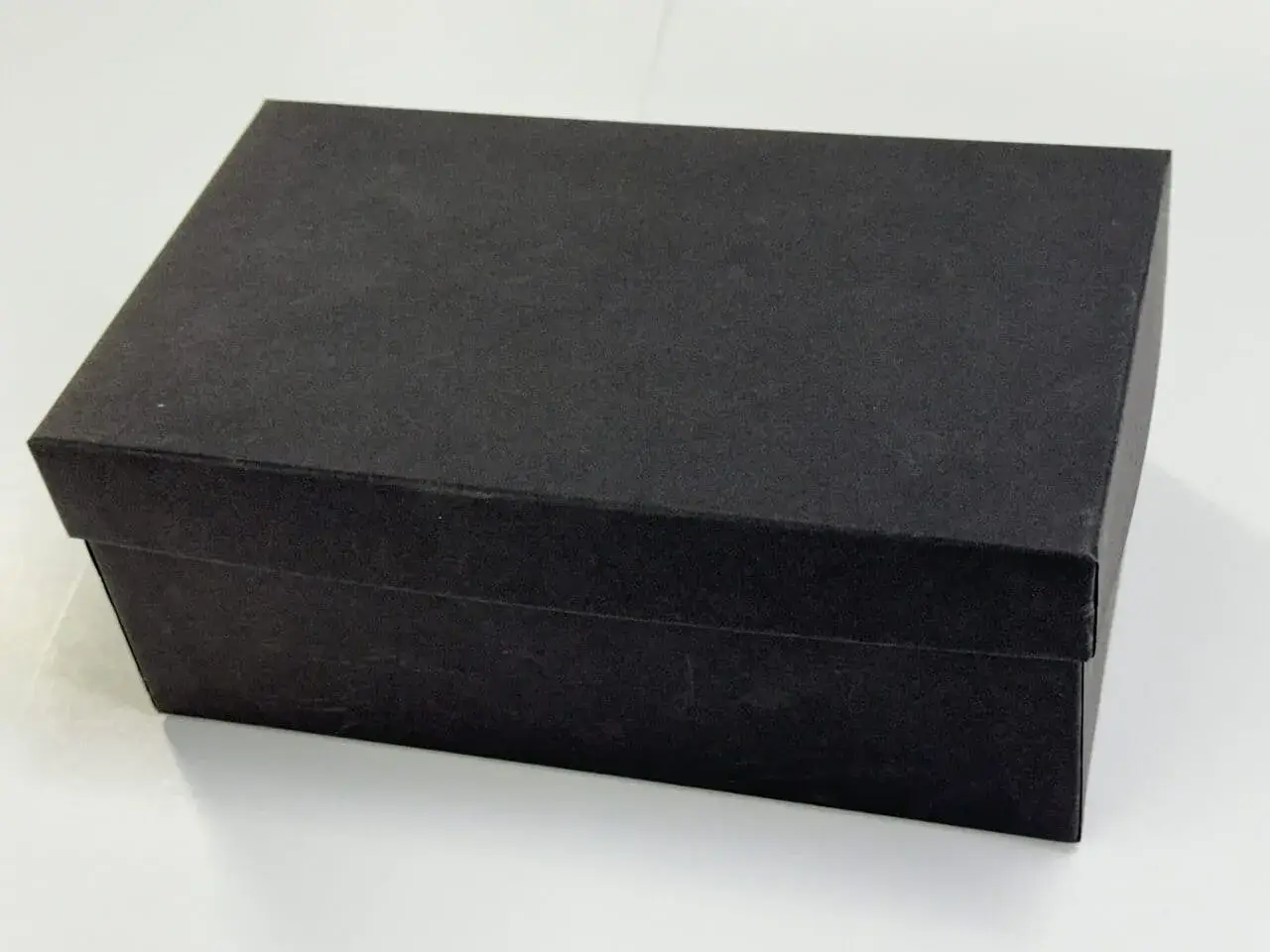 Black Shoebox styled rigid two-piece box with white background.